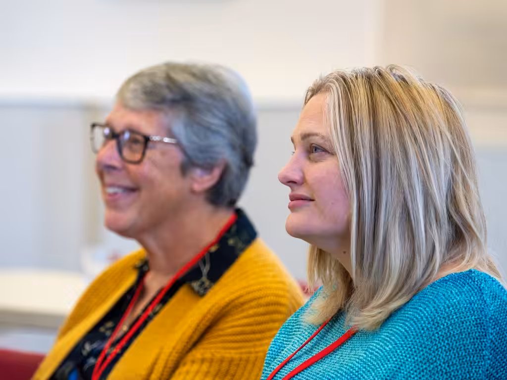 Two women listening carefully in a classroom