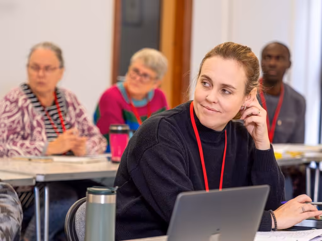 A woman sitting in a classroom talking to classmates