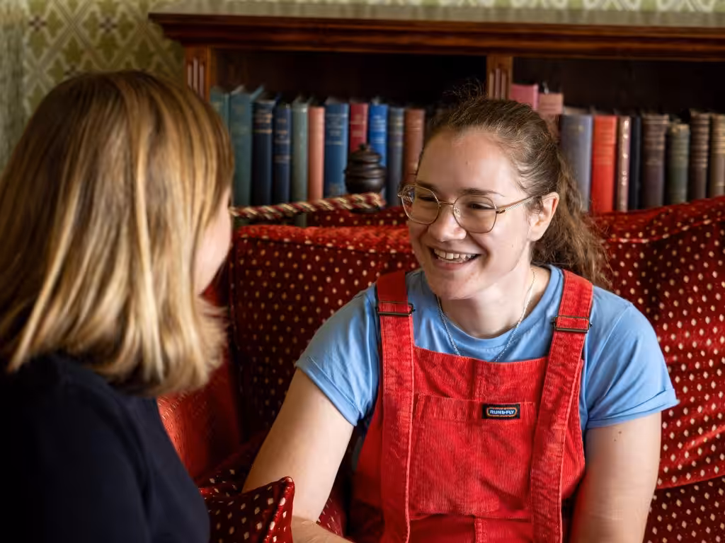 A woman talking to another woman who is smiling and looking encouraged